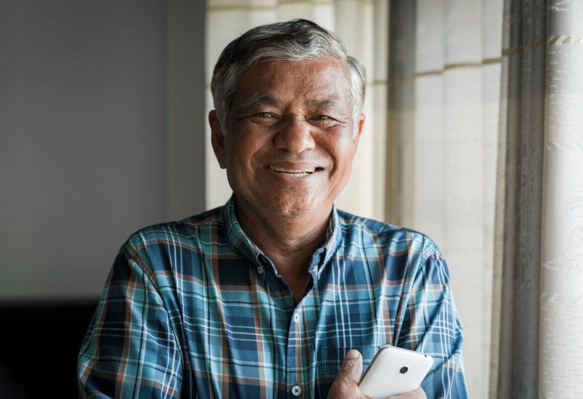 Image of an older man smiling following his dental visit at home. - mobile