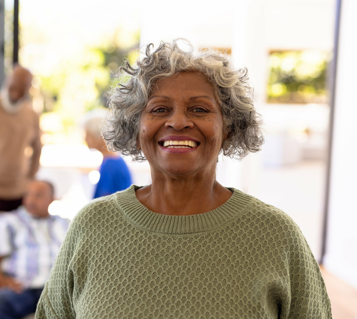 Portrait of smiling african american senior woman standing with - mobile