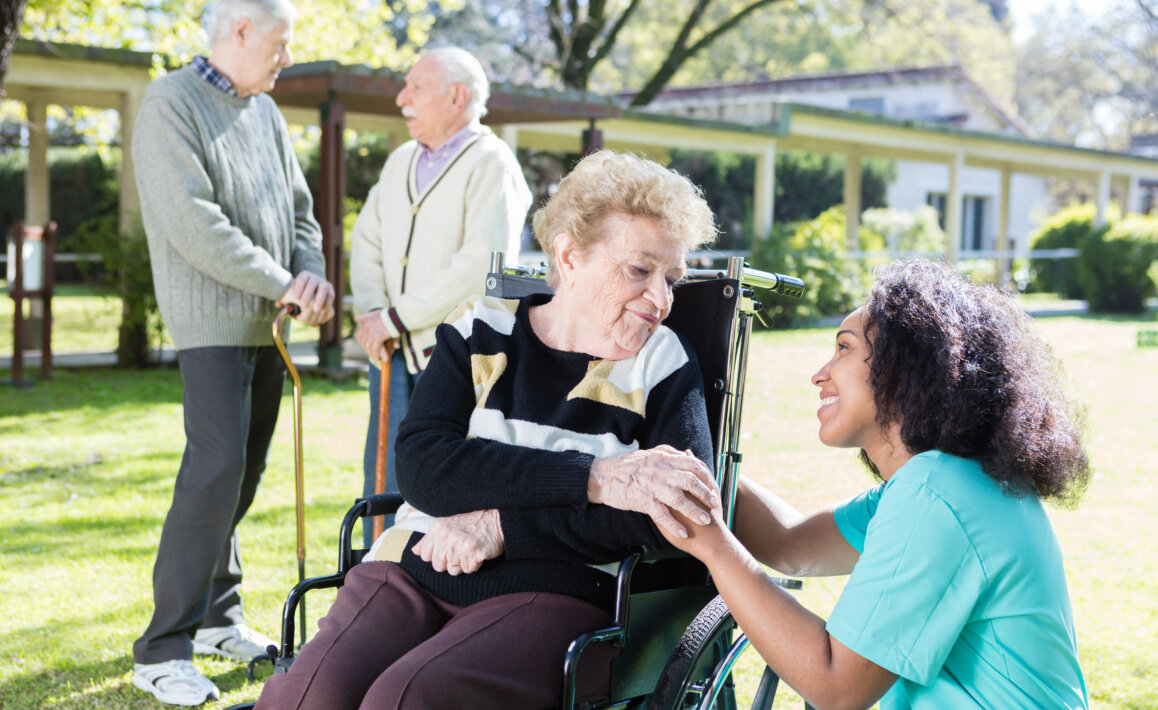 Dental assistant consulting with patient in a senior living home setting.